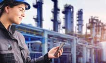 A refinery worker looking at her smartphone.
