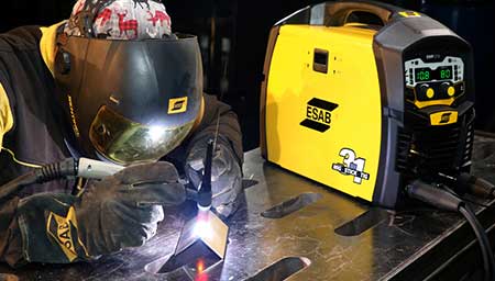 A TIG welder using an ESAB welding machine, wearing ESAB PPE.