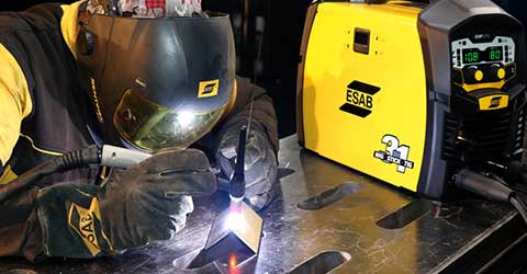 A TIG welder using an ESAB welding machine, wearing ESAB PPE.