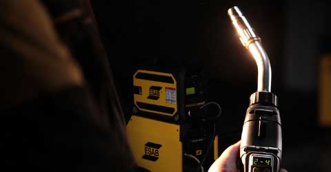 A digital TWECO MIG welding gun with an ESAB weldeing machine in the background.