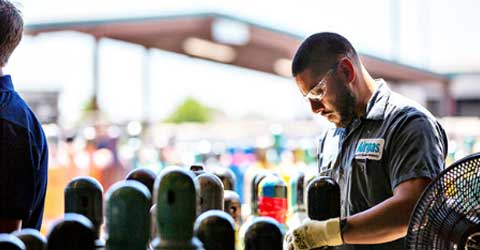 An Airgas worker maintaining and preparing gas cylinders.