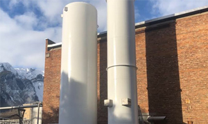 Two nitrogen storage tanks — taller than the red brick building behind them